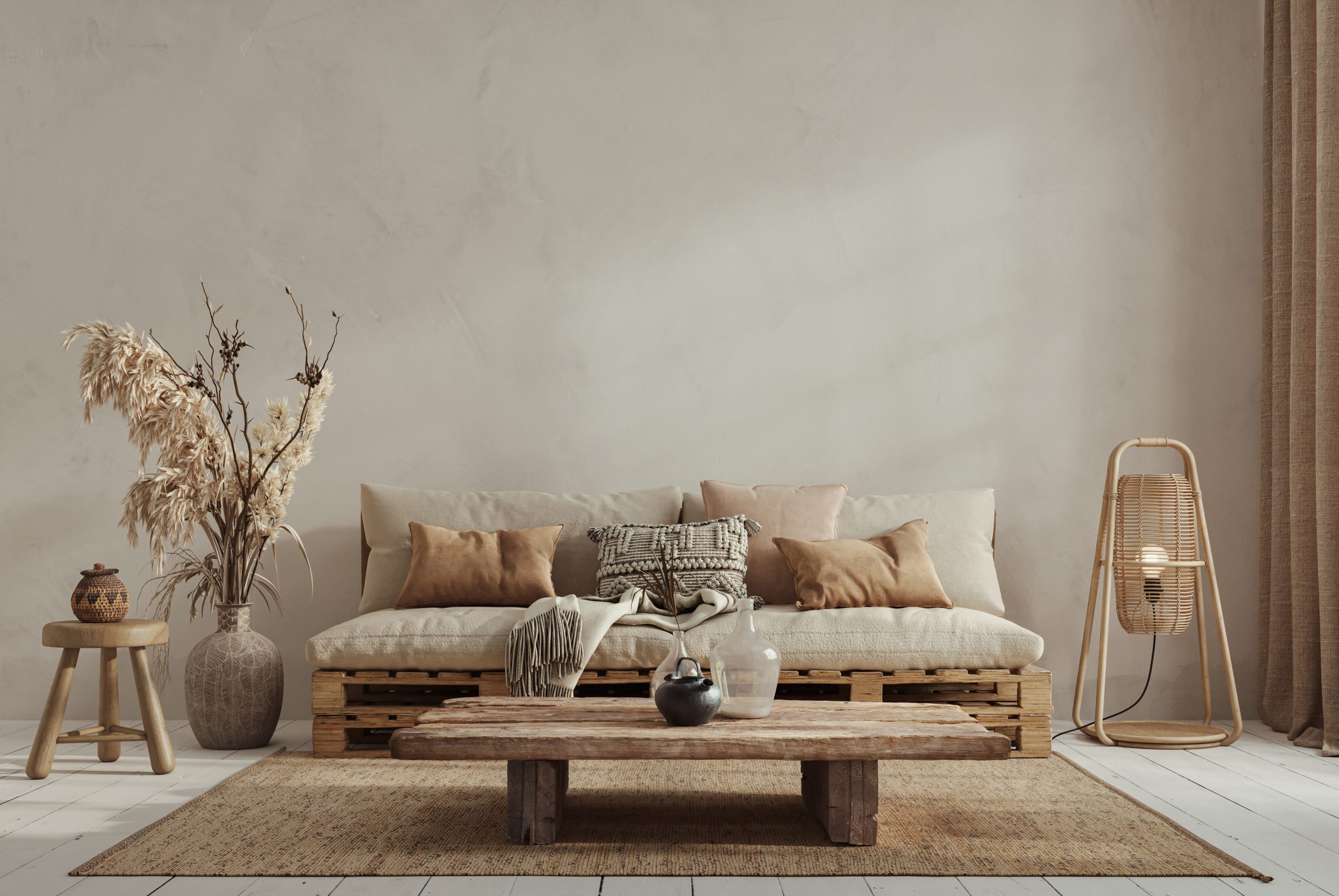 AdobeStock_694909181 Cozy living room with a pallet sofa, neutral cushions, wooden coffee table, and rustic decor elements.